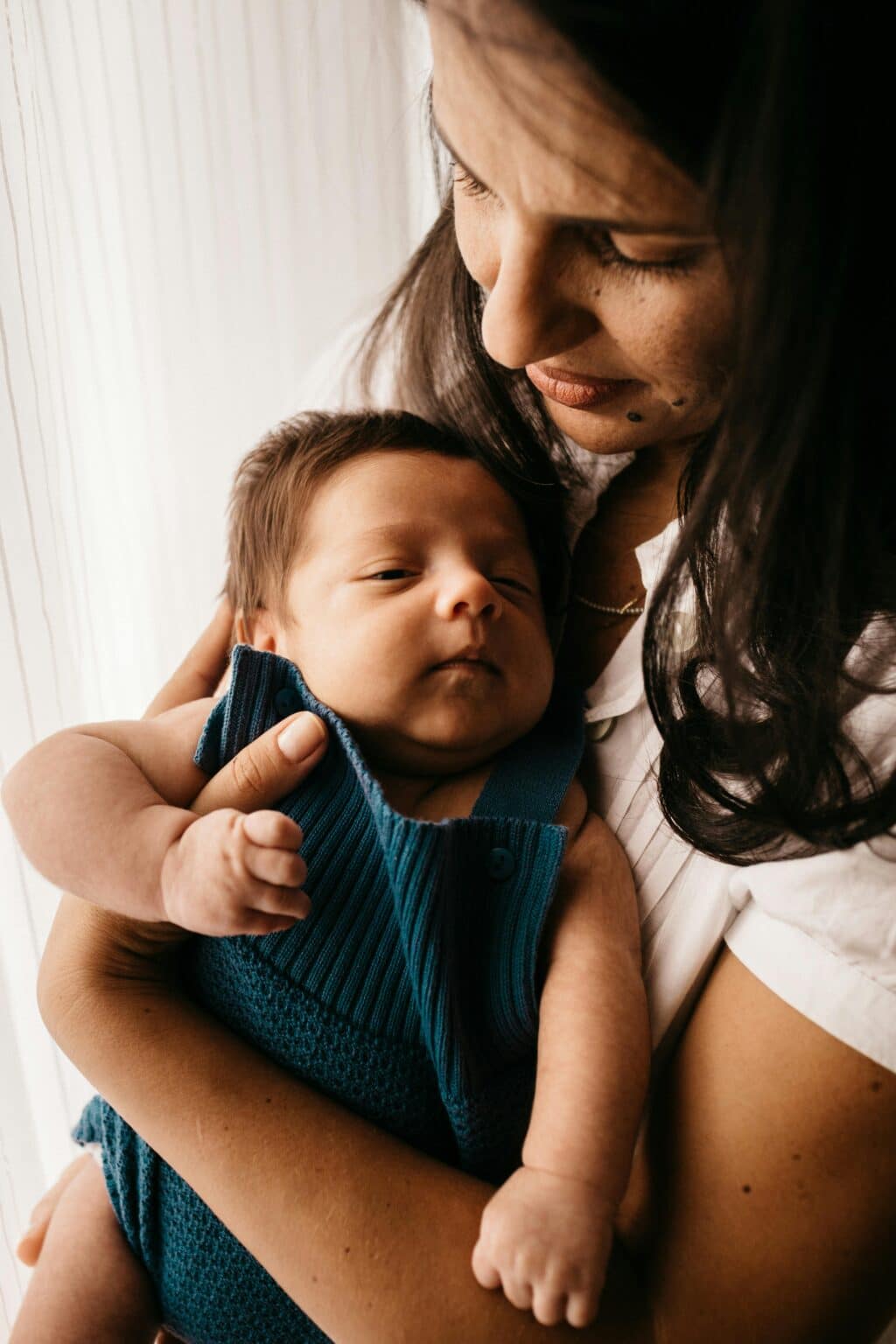 A mother holds a baby in her arms.